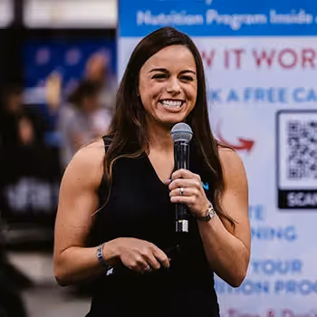 Smiling speaker holding microphone at professional conference or event