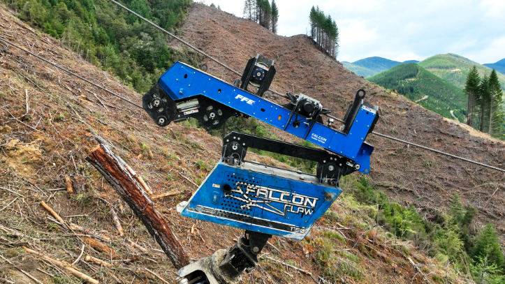 Blue Falcon Claw forestry machine gripping a log on a steep hillside with cleared and forested areas.