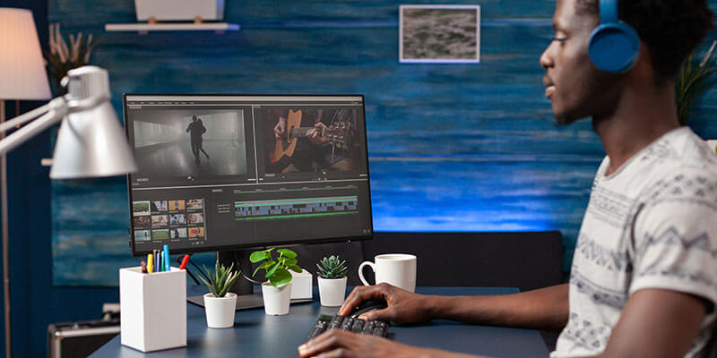 A remote video editor reviews footage on his computer