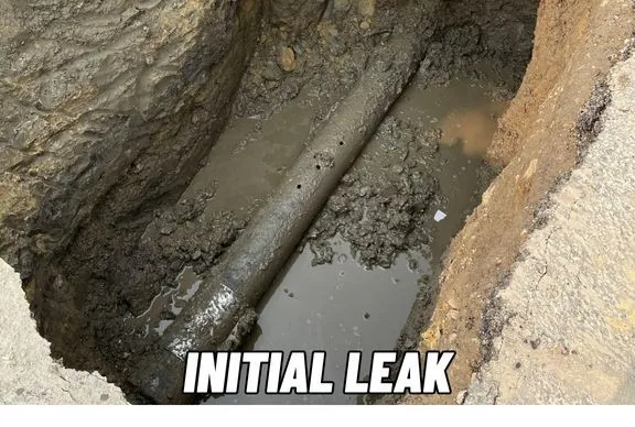 Red industrial piping system with vertical black pipes, pressure gauges, valves, and control devices in a utility room.