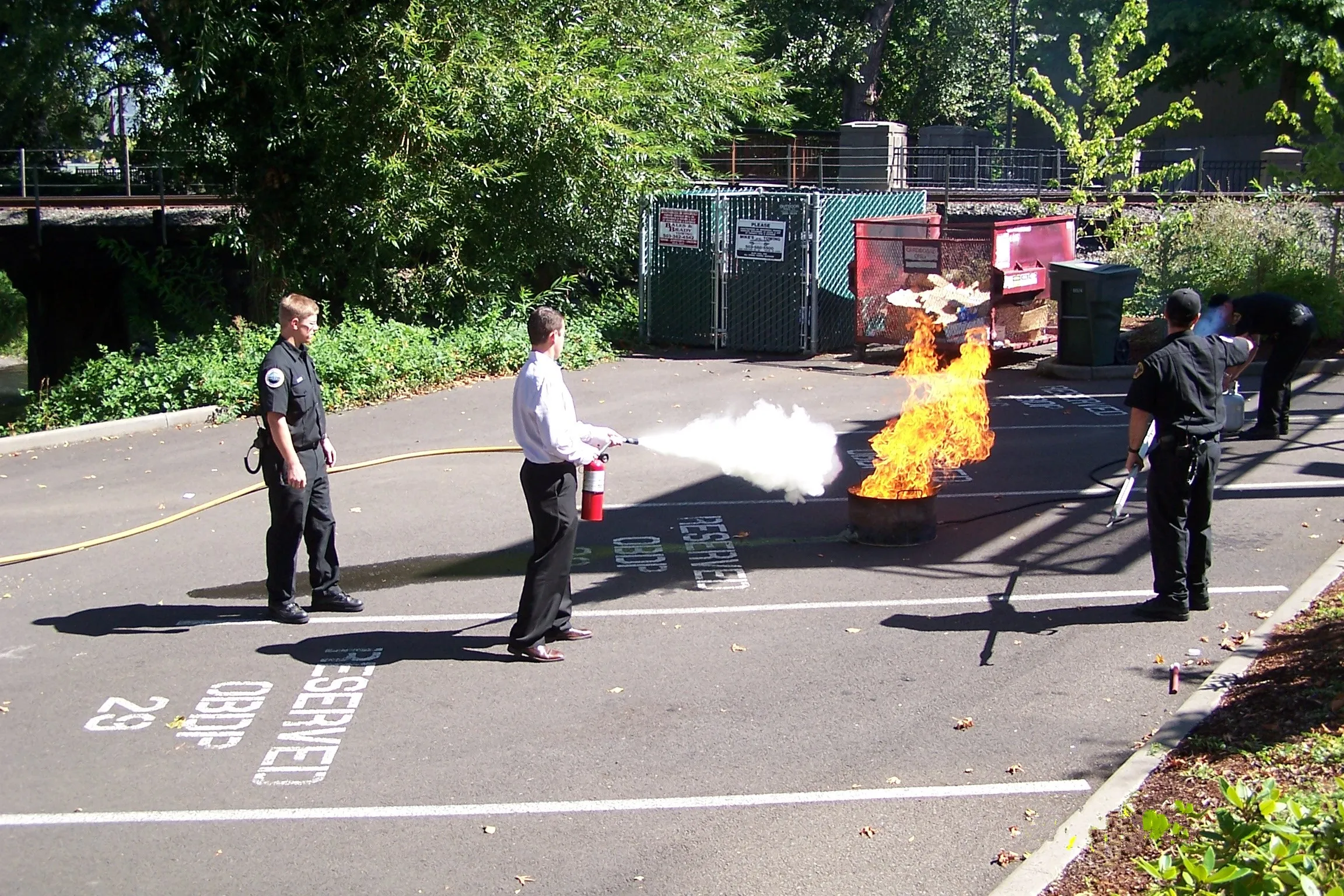Person in navy shirt holding a red Amerex fire extinguisher with instruction label.