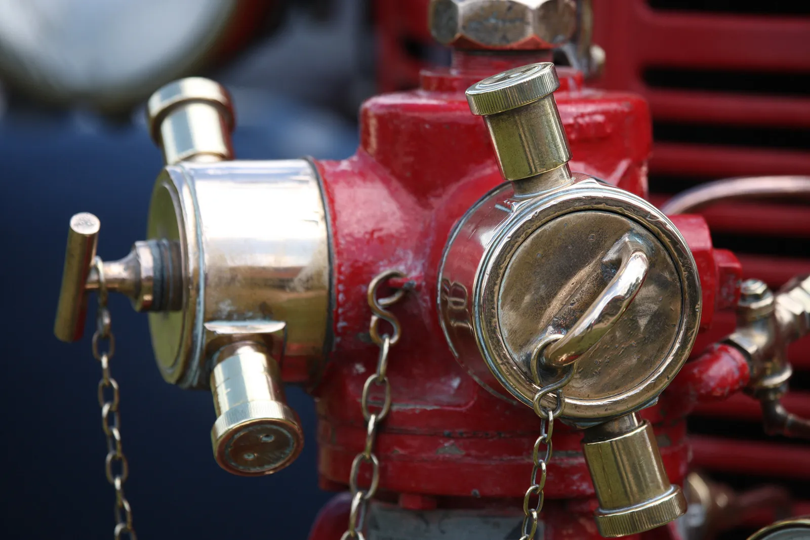 Technician in a Spectrum Fire Protection hoodie working on industrial pipes and gauges in a utility closet.
