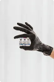 Practitioner's gloved hand holding a medical product