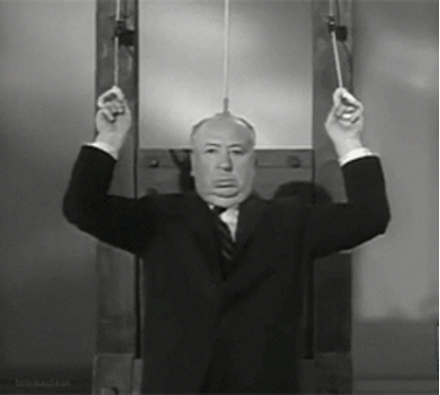 Black and white GIF of a man in a suit making humorous faces while pulling himself up on gymnastic rings.