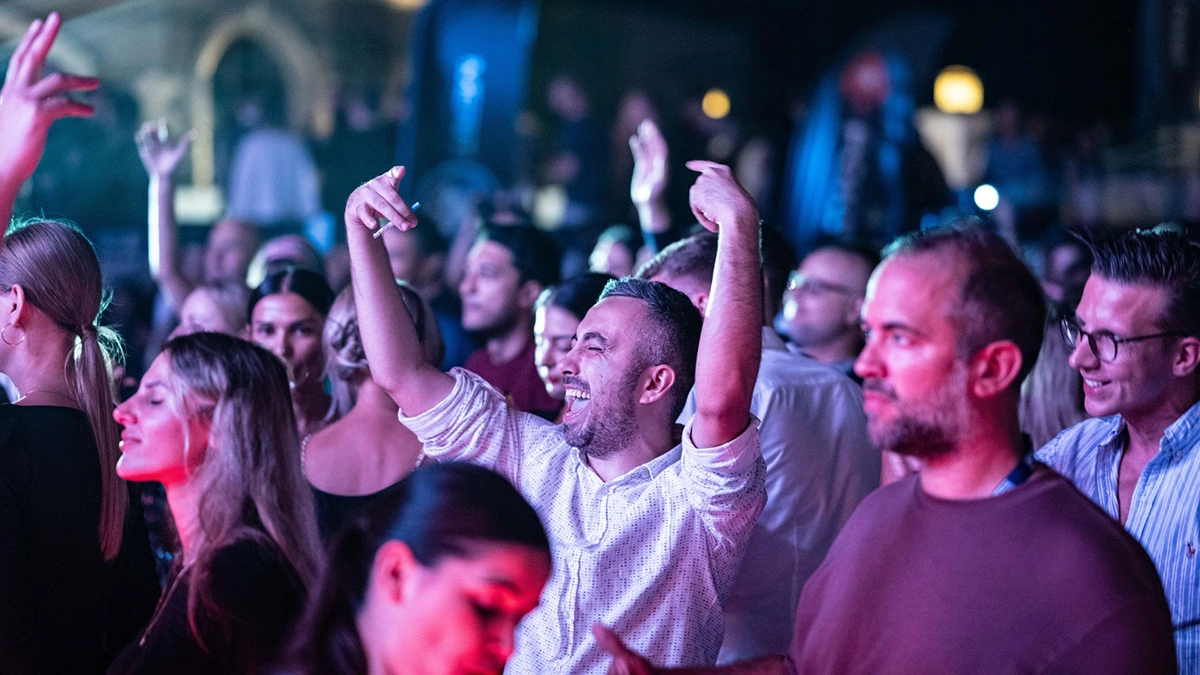 Close up of a group of people dancing and having a great time at a concert.
