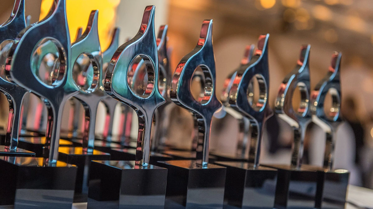 Close-up of a table full of trophies in at an award ceremony.