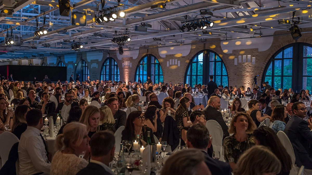 A ballroom full of people having dinner at an event.