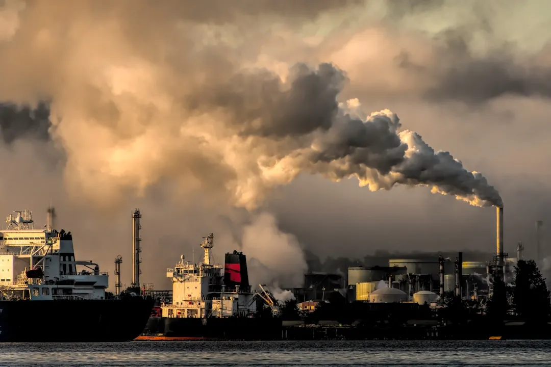 industrial harbor with smokestack pollution. Photo by Chris LeBoutillier on Unsplash