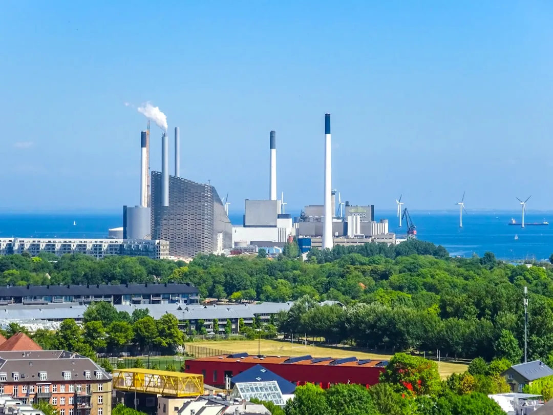 Industrial power plant with smokestacks by the ocean.. Photo by Nikolai Kolosov on Unsplash