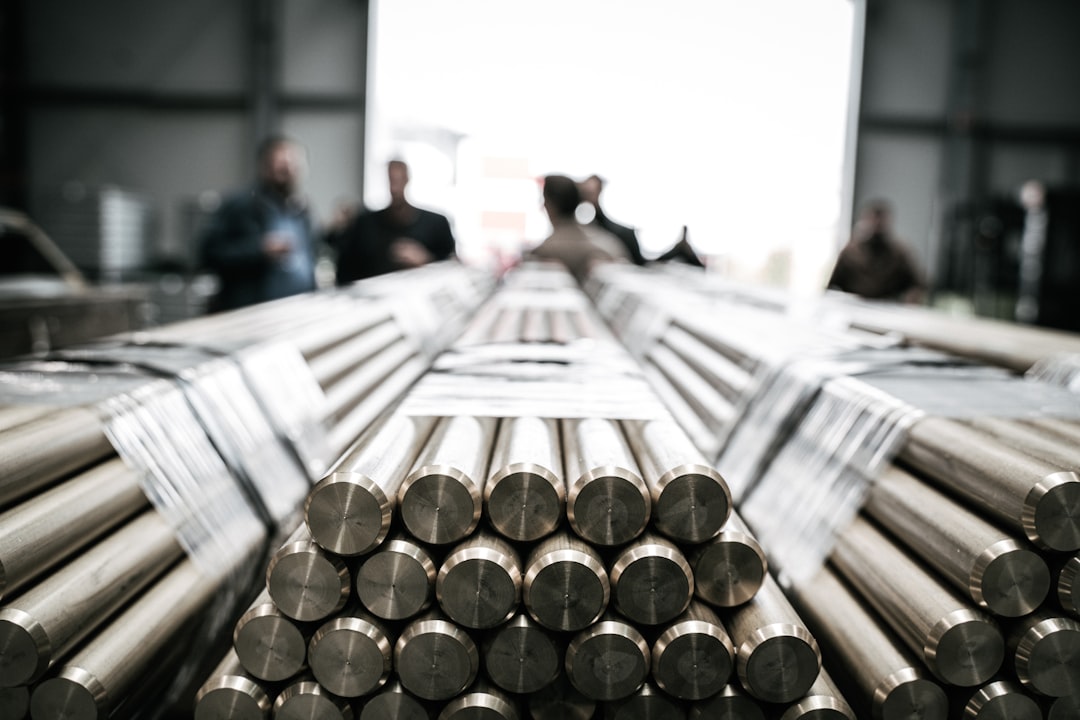 a group of people standing around a pile of metal rods — Photo by Kasper Gant on Unsplash