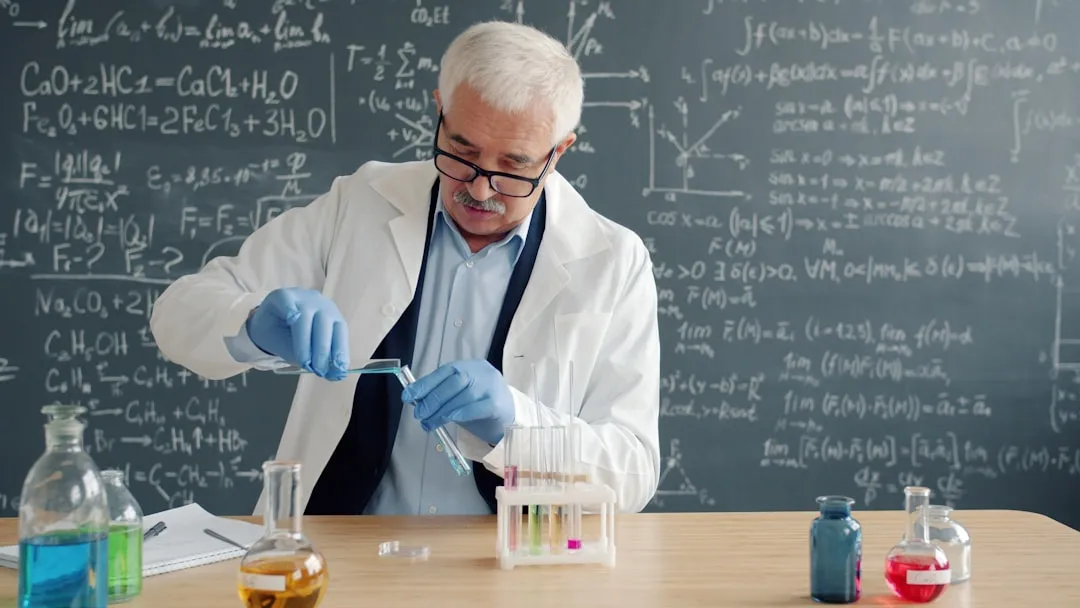 Scientist in lab coat conducts experiment with test tubes.. Photo by Vitaly Gariev on Unsplash