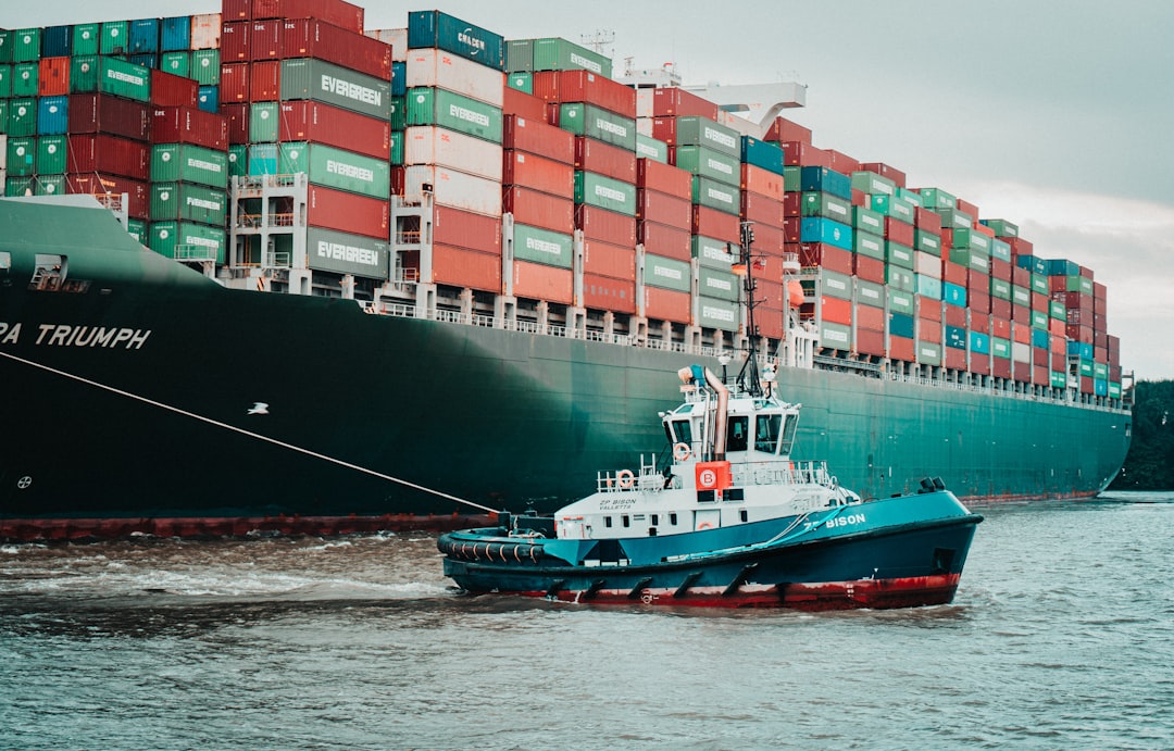 a tug boat pulling a large container ship — Photo by Mika Baumeister on Unsplash