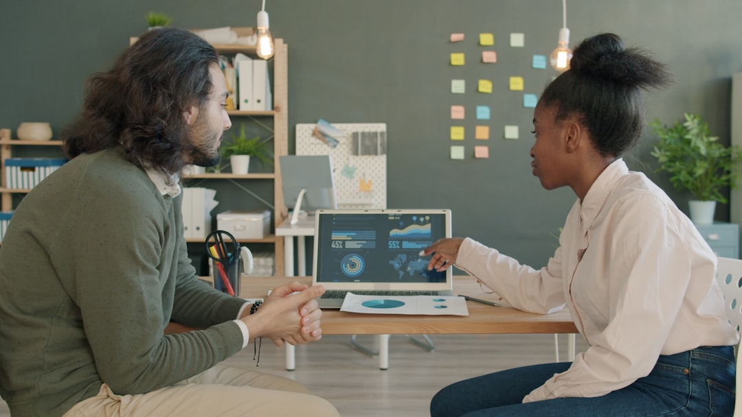 Two colleagues discussing data on a laptop screen. — Photo by Vitaly Gariev on Unsplash