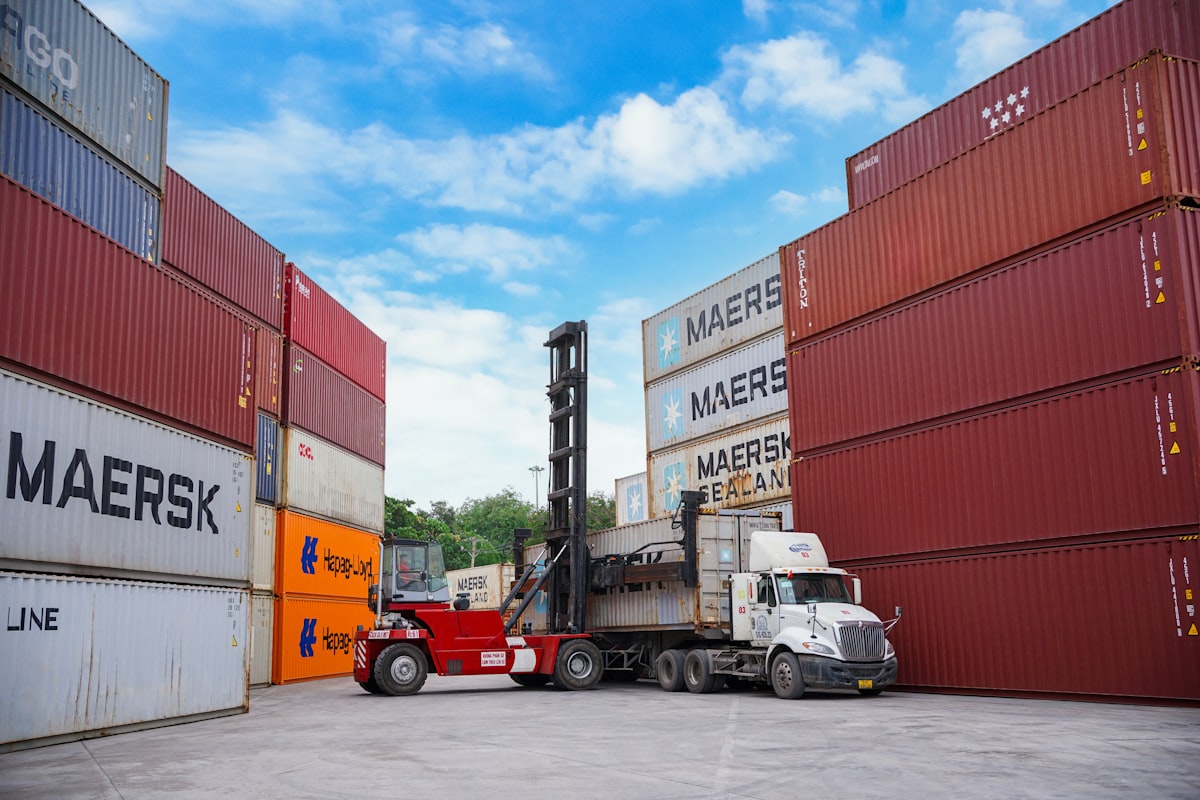 Forklift moving shipping containers at a port. — Photo by Solømen on Unsplash