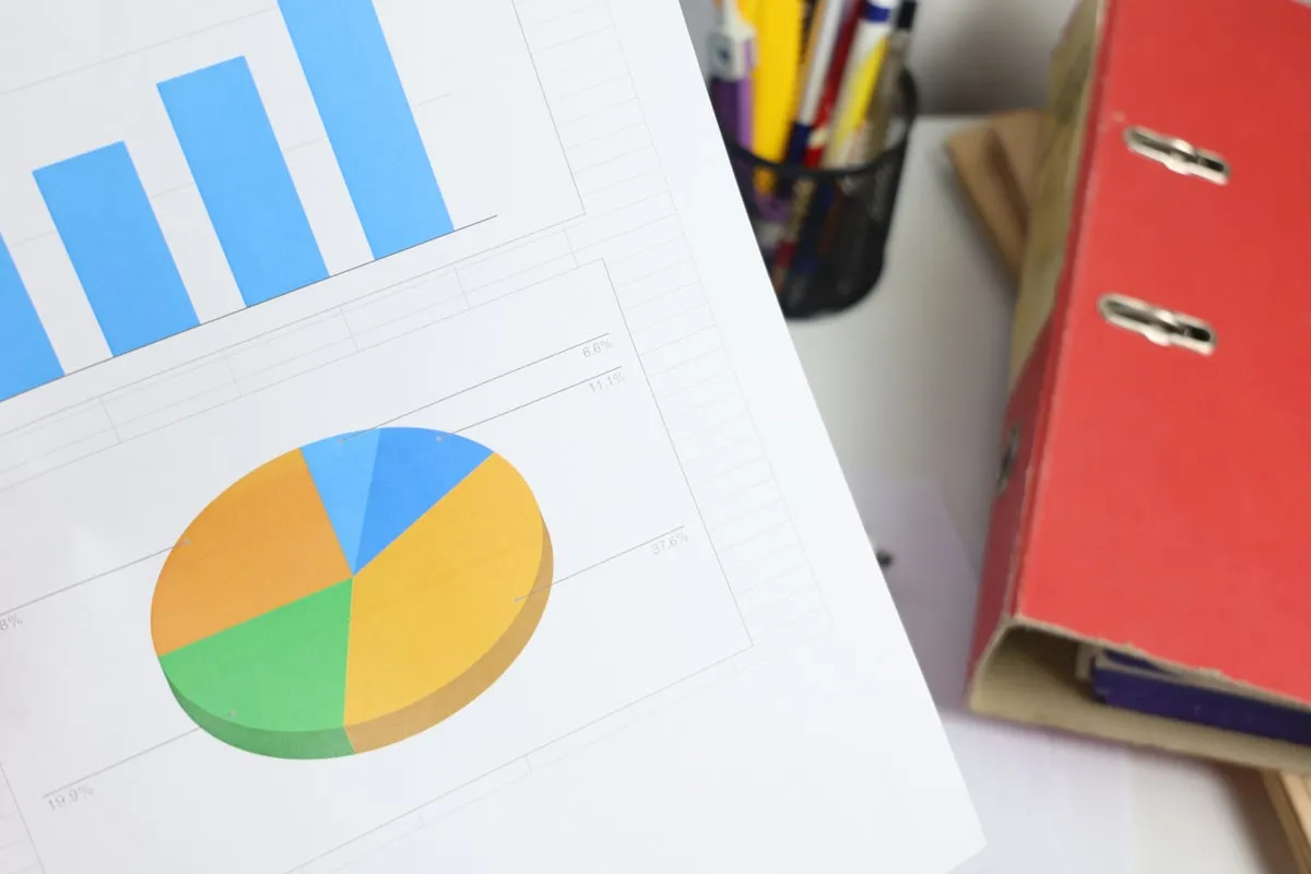 Bar and pie charts on a document. Photo by Cht Gsml on Unsplash