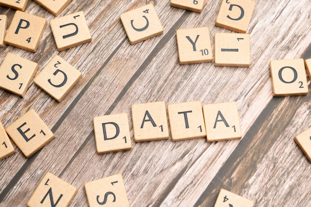 scrabble tiles spelling out the word data on a wooden surface. Photo by Markus Winkler on Unsplash
