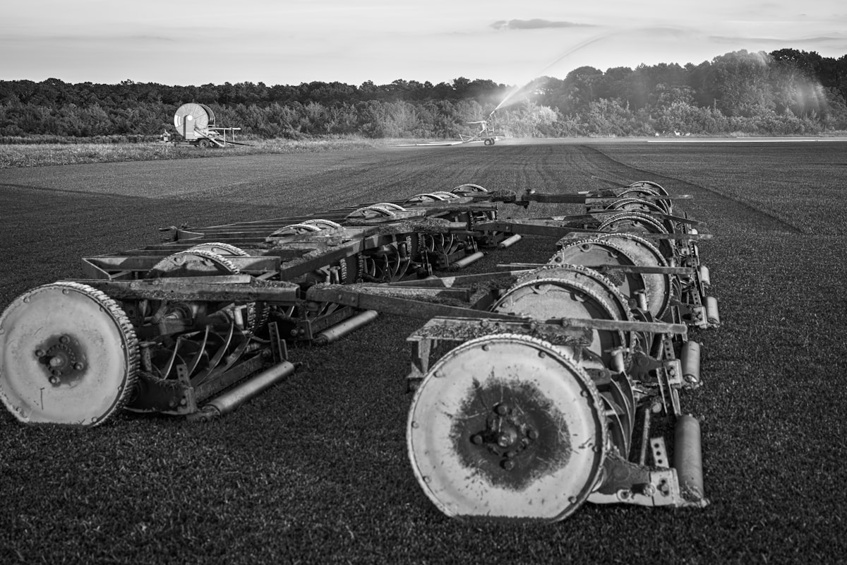 Agricultural machinery in a field with sprinklers. — Photo by Lumin Osity on Unsplash