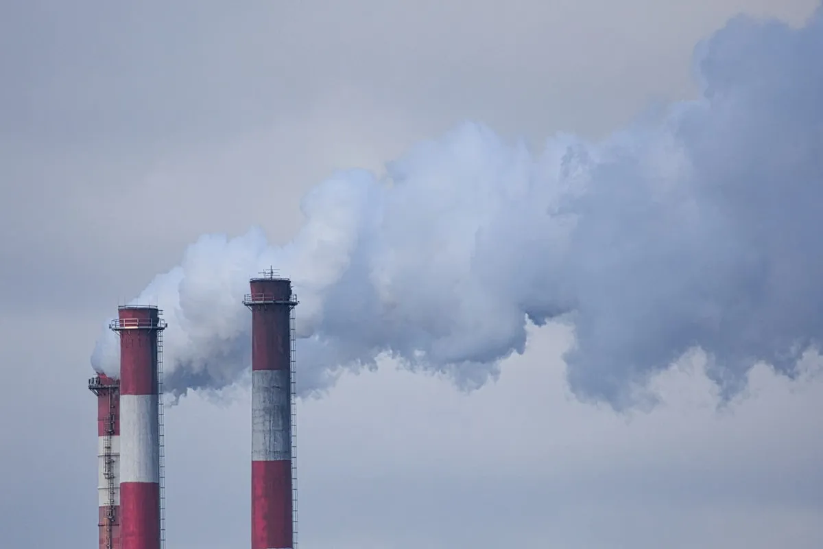 smoke billows from the stacks of smoke stacks. Photo by Kaptured by Kasia on Unsplash