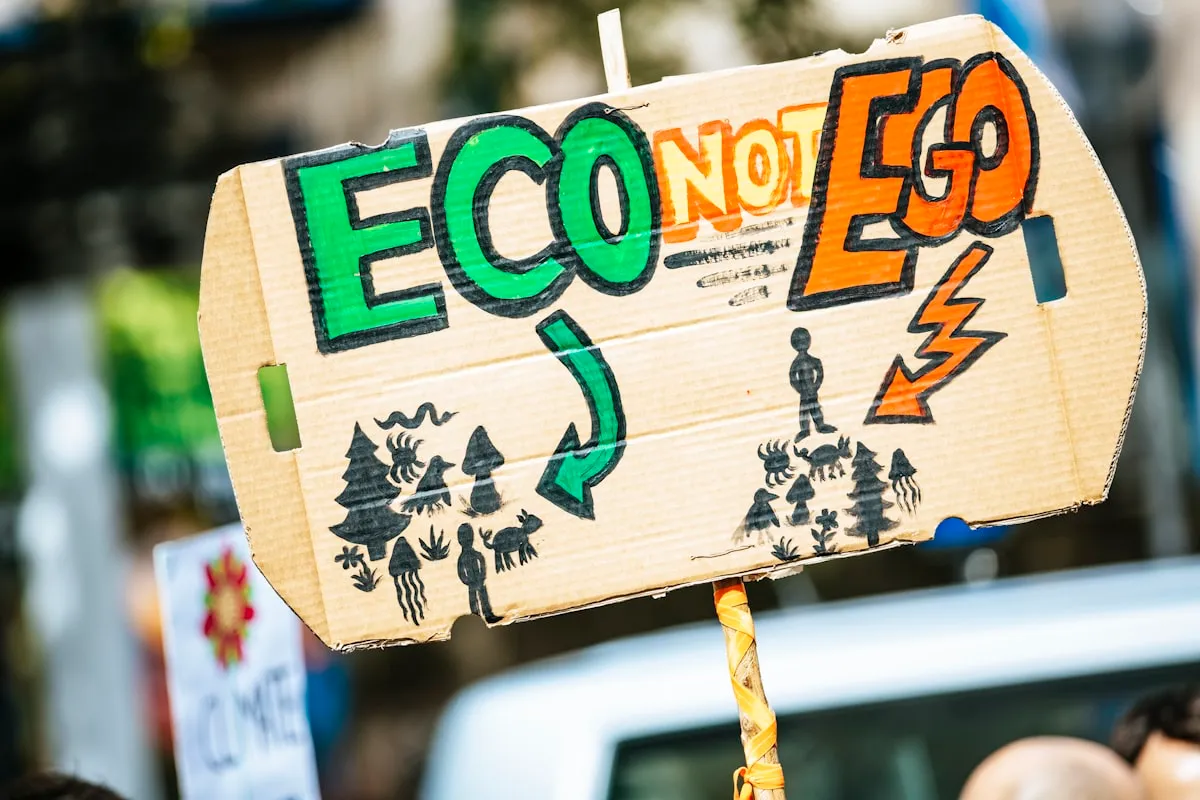 person holding Eco Not Ego signage. Photo by Markus Spiske on Unsplash