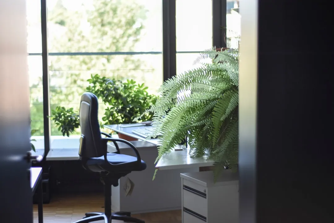 black leather rolling armchair near white wooden desk, Photo by Unknown Wong on Unsplash