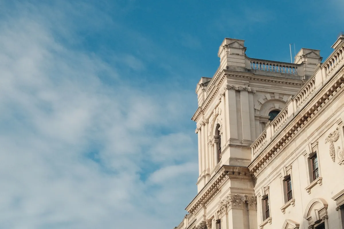 Ornate white building facade against a blue sky, Photo by Miralem-Davy Copra on Unsplash