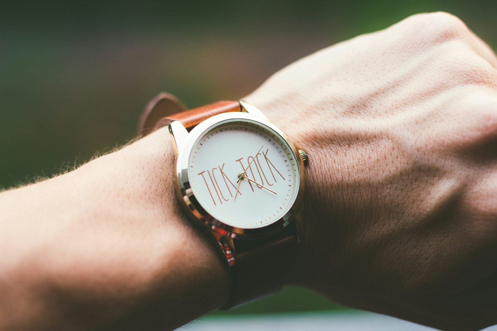 A wristwatch with a face reading tick tock, on a person's wrist