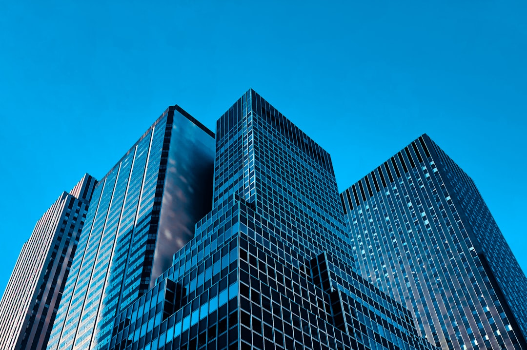 Glass skyscrapers seen from below against a blue sky