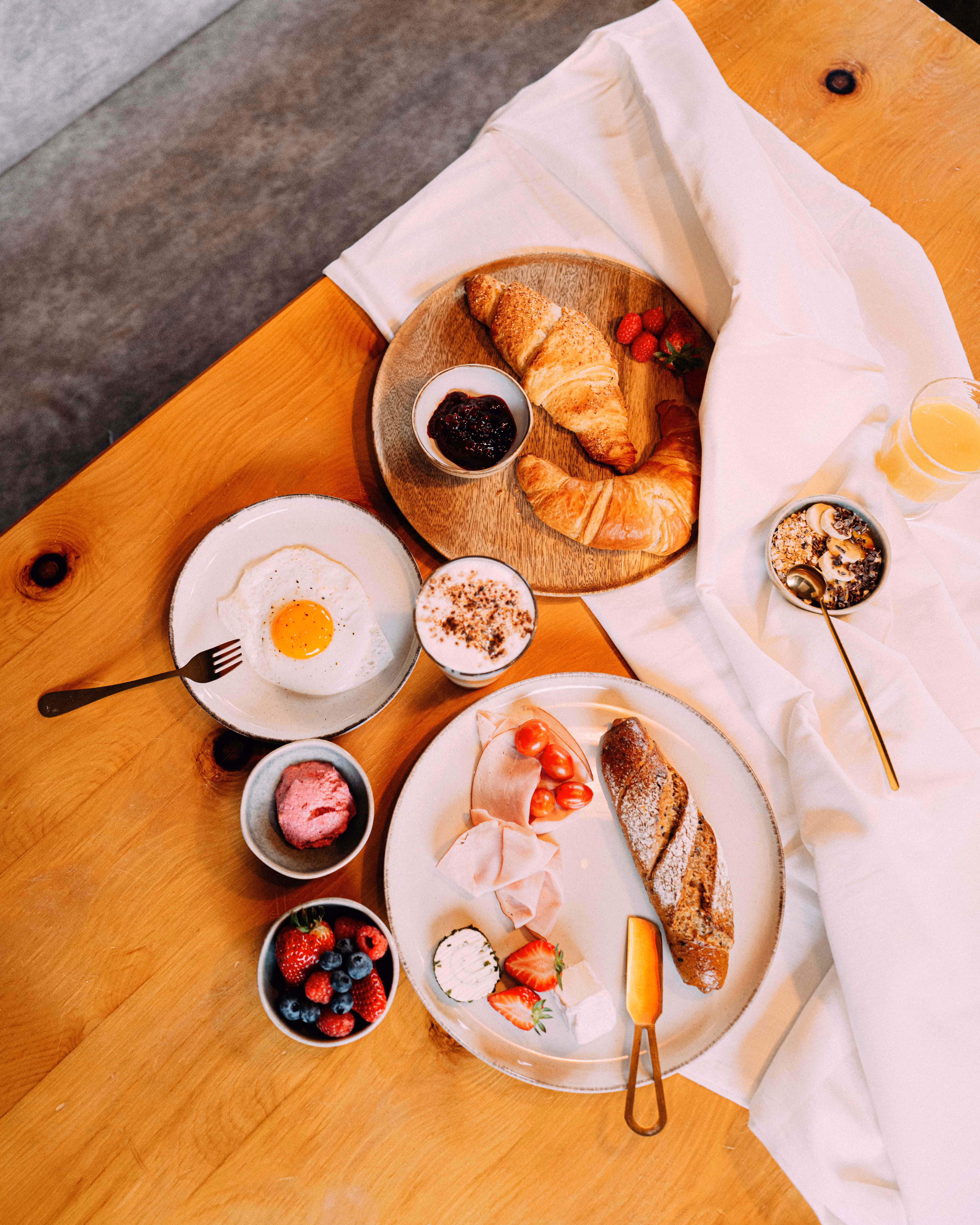 Frühstück von oben mit Croissant, Ei und Beeren im afoch fei Boutique Hotel St. Anton am Arlberg