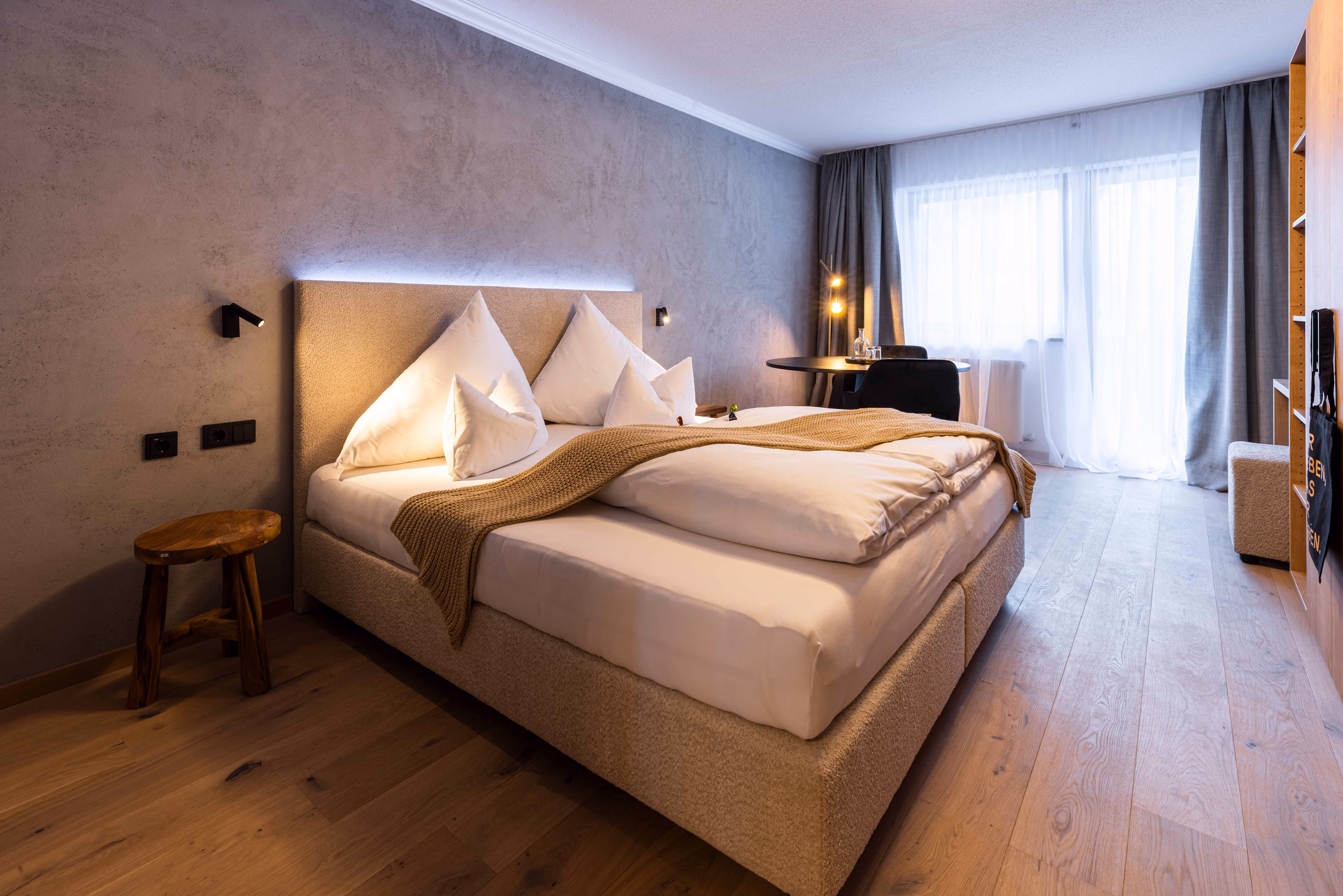 Helles Studio mit Boxspringbett und moderner Einrichtung im afoch fei Boutique Hotel St. Anton am Arlberg