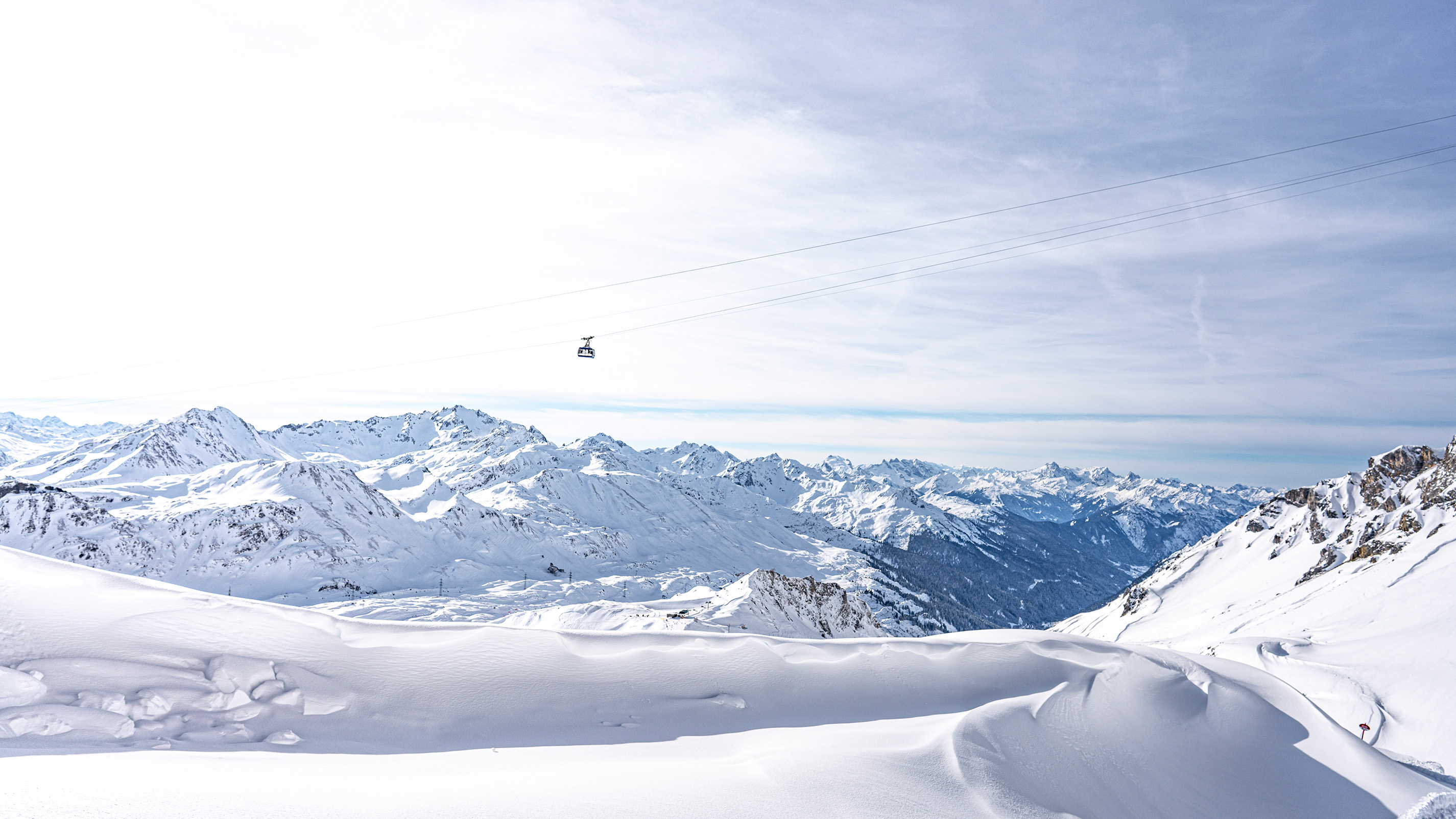 Panoramablick über das verschneite Skigebiet Arlberg mit Gondelbahn