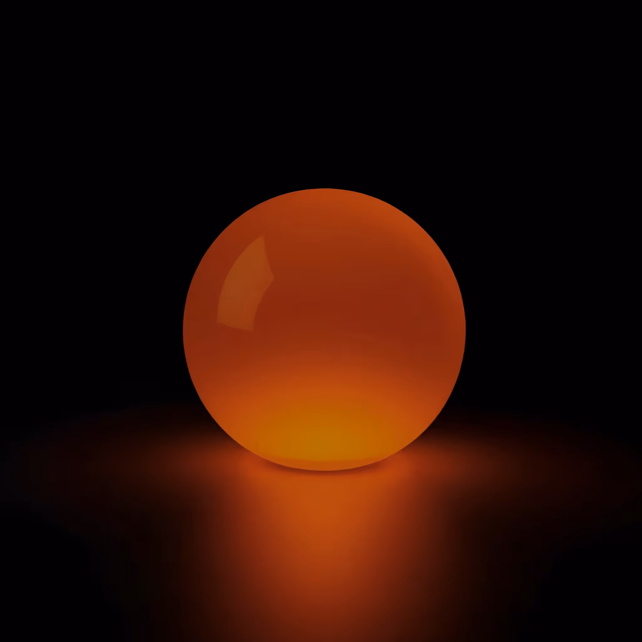 A glowing orange sphere casting a soft light on a dark surface with a black background.