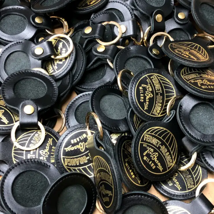 A group of leather keyrings that hold commemorative coins issued by Fernet Branca