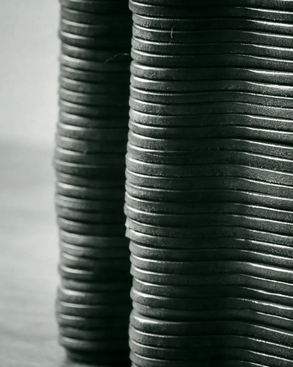 a stack of shaped leather coasters showing details of the edge finishing