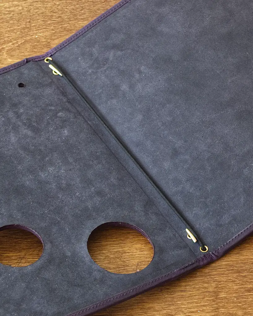 Detail of a nubuck leather menu showing the elastic binding to hold the pages in place