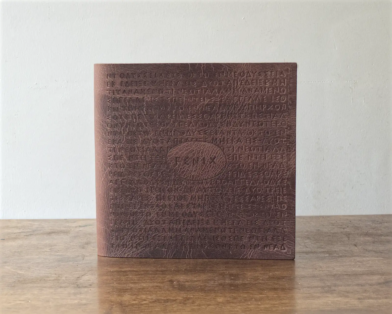 A rustic heavy leather menu with large brand stamp on the cover.