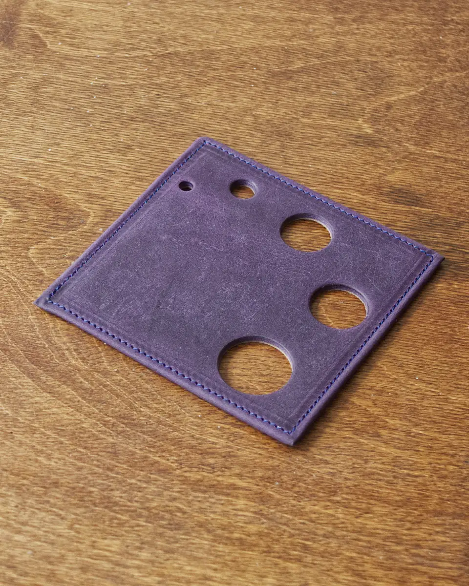 Nubuck drinks coaster with decorative holes punched through it