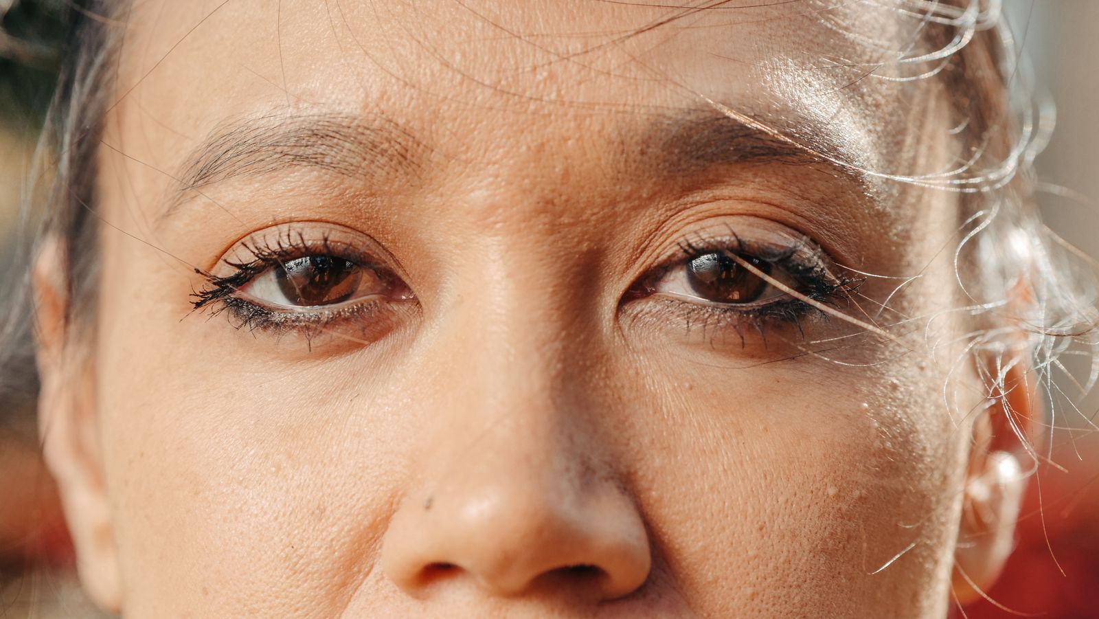 Close-up of a woman's eyes and under-eye area in soft natural daylight