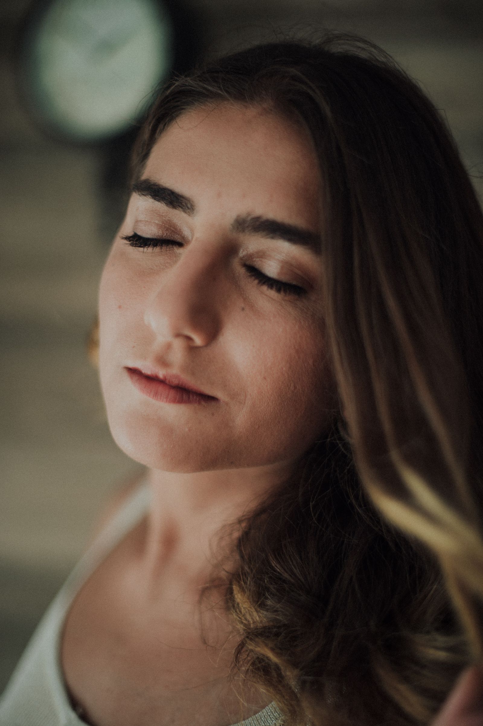 Close-up portrait of a woman with her eyes closed in soft natural light