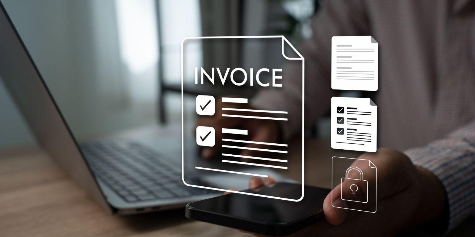 Person holding smartphone with digital invoice icons and a laptop keyboard in the background.