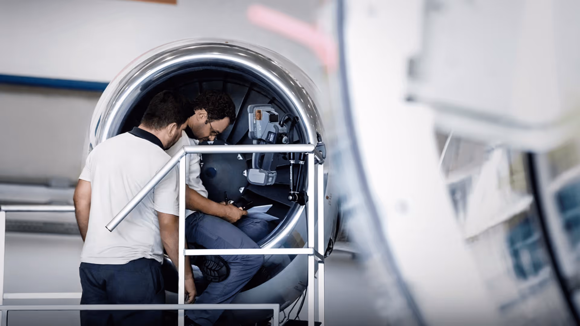 Photo of engineers inspecting business jet engine.