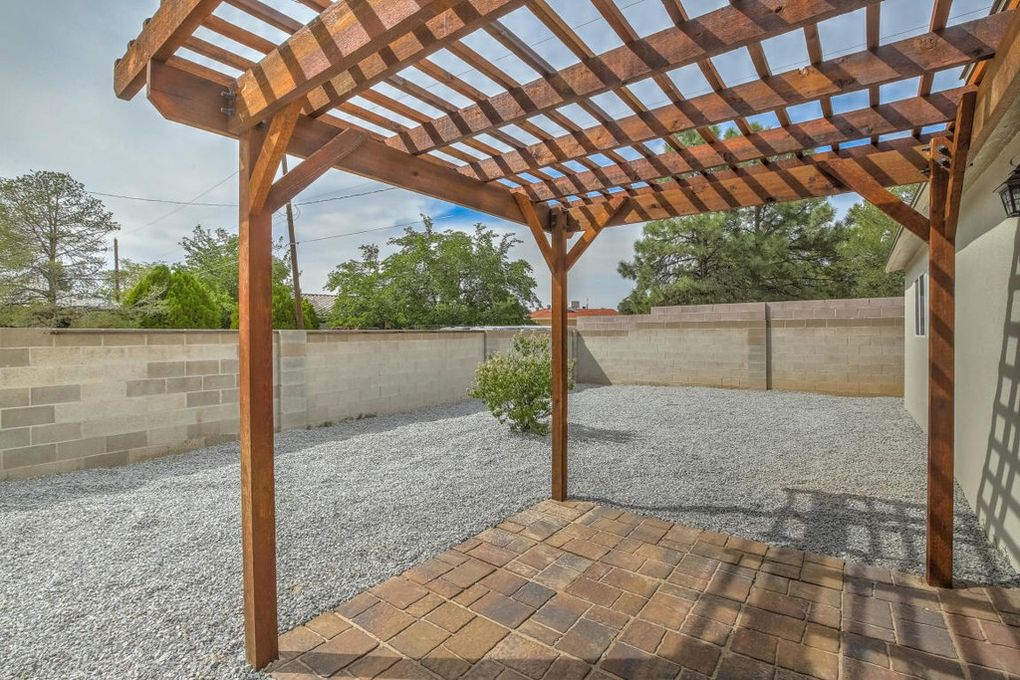 Rough sawn cedar pergola with paver walkout patio in Northeast Heights
