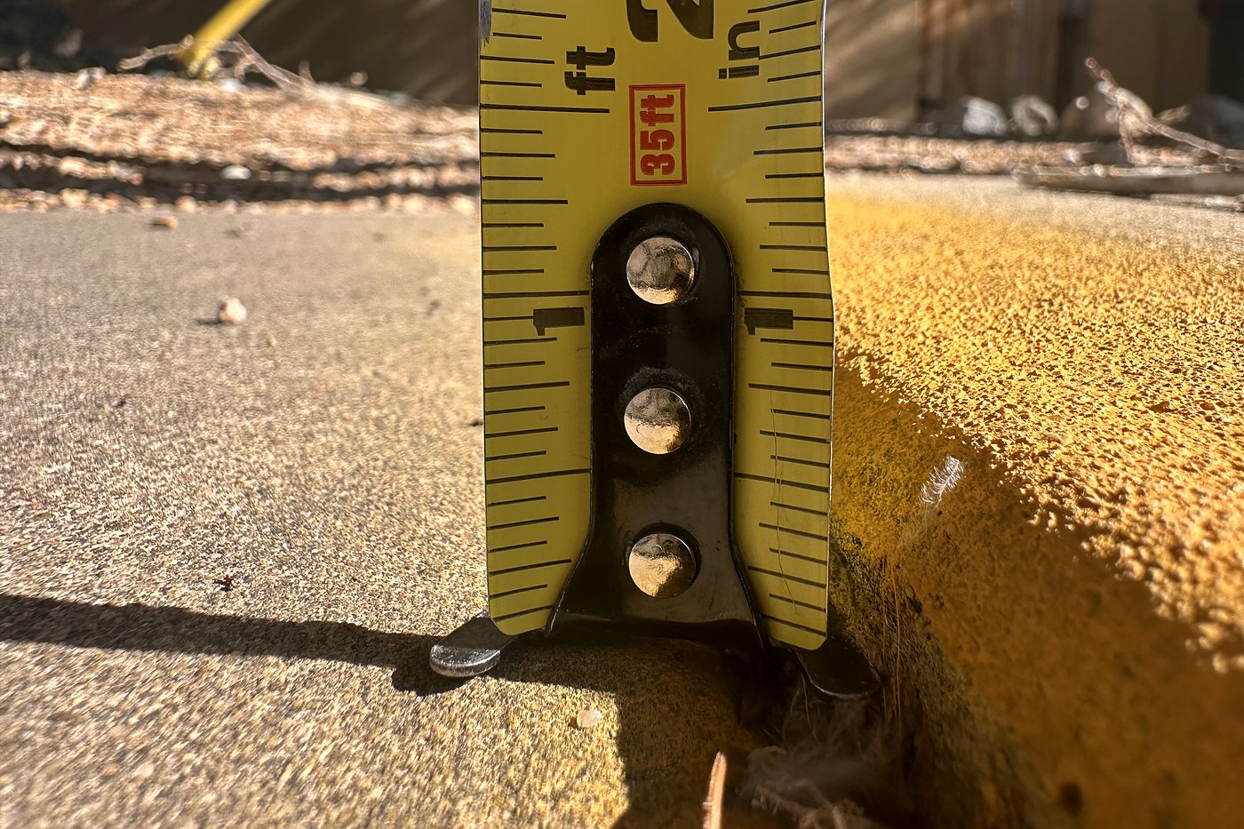 Tape measure documenting the height of a raised sidewalk edge