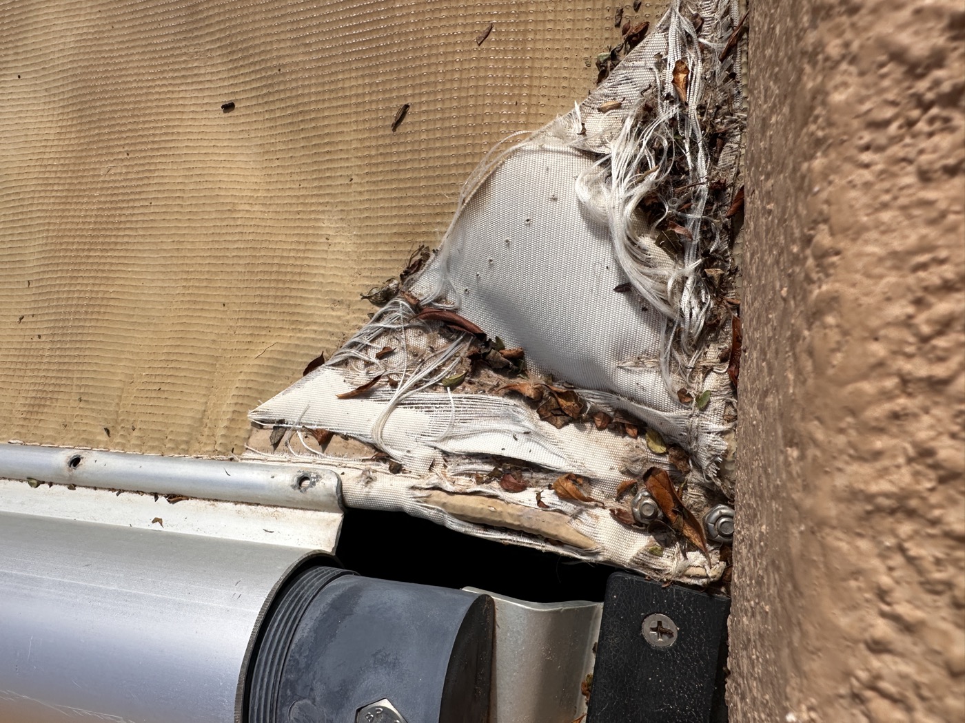 Torn and frayed pool cover fabric beside the leading bar before replacement on a Tate Construction project in Albuquerque