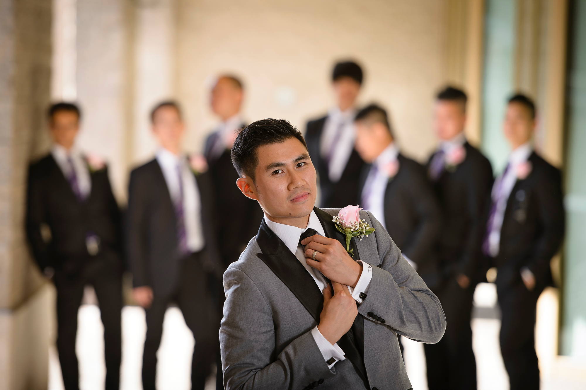 Groom adjusting his boutonniere with his groomsmen lined up behind him, Halifax wedding