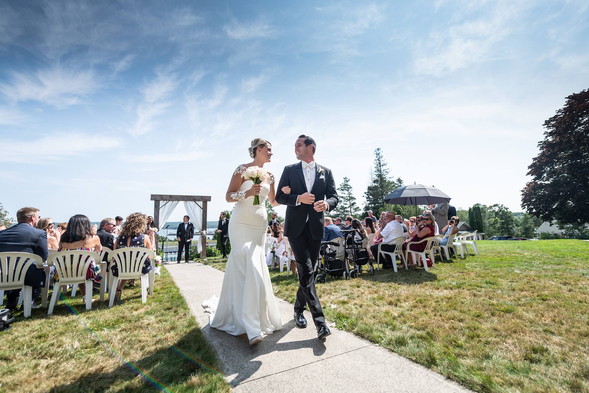 Bride and groom walking back up the aisle after an outdoor ceremony by the water in Nova Scotia