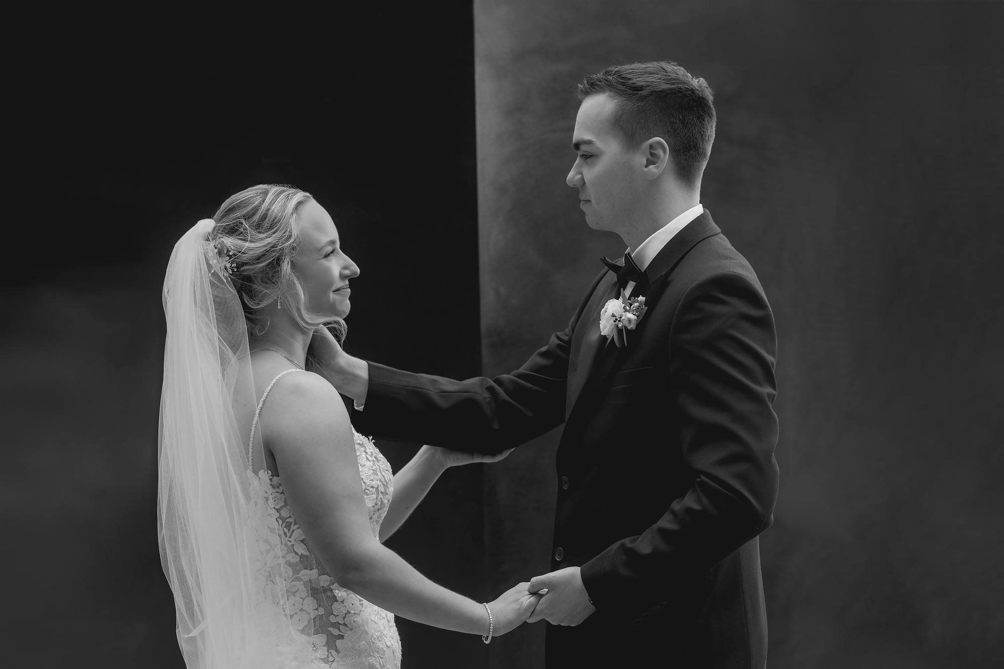 Bride and groom holding hands in a quiet moment, black and white wedding portrait