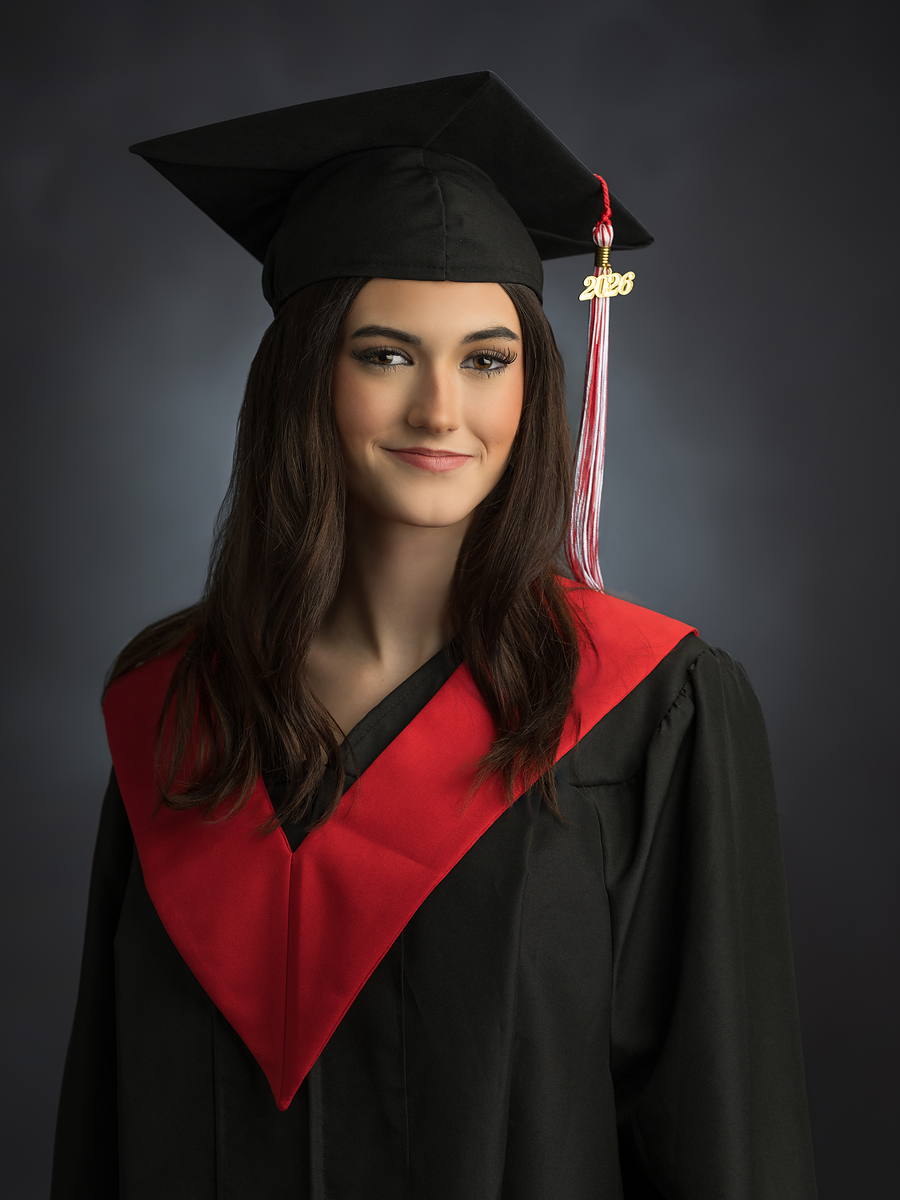 University grad in cap and gown with a red hood, studio graduation portrait in Halifax