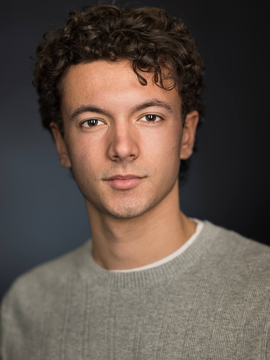 Casual grad portrait of a young man in a grey sweater, studio headshot style, Halifax