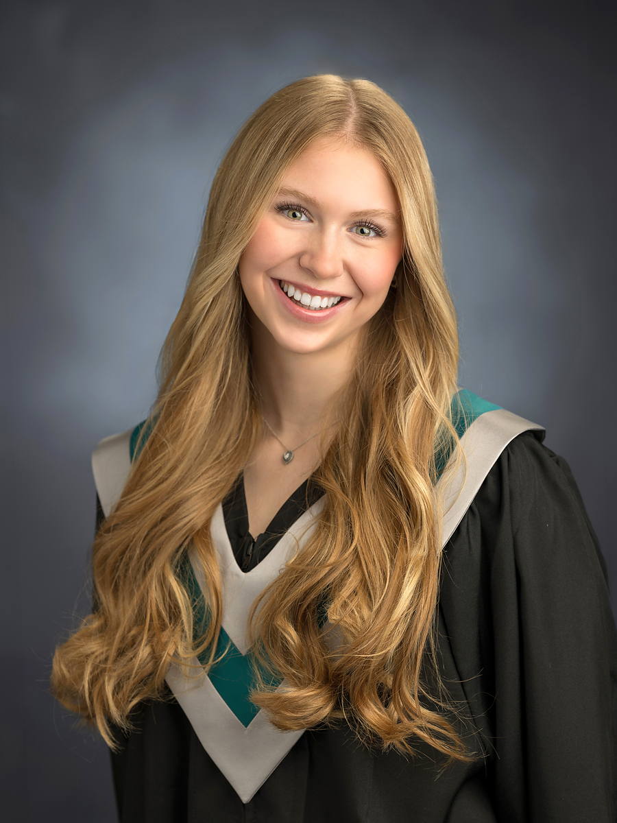 Grad with long blonde hair in a black gown with a teal and white sash, Halifax grad portrait