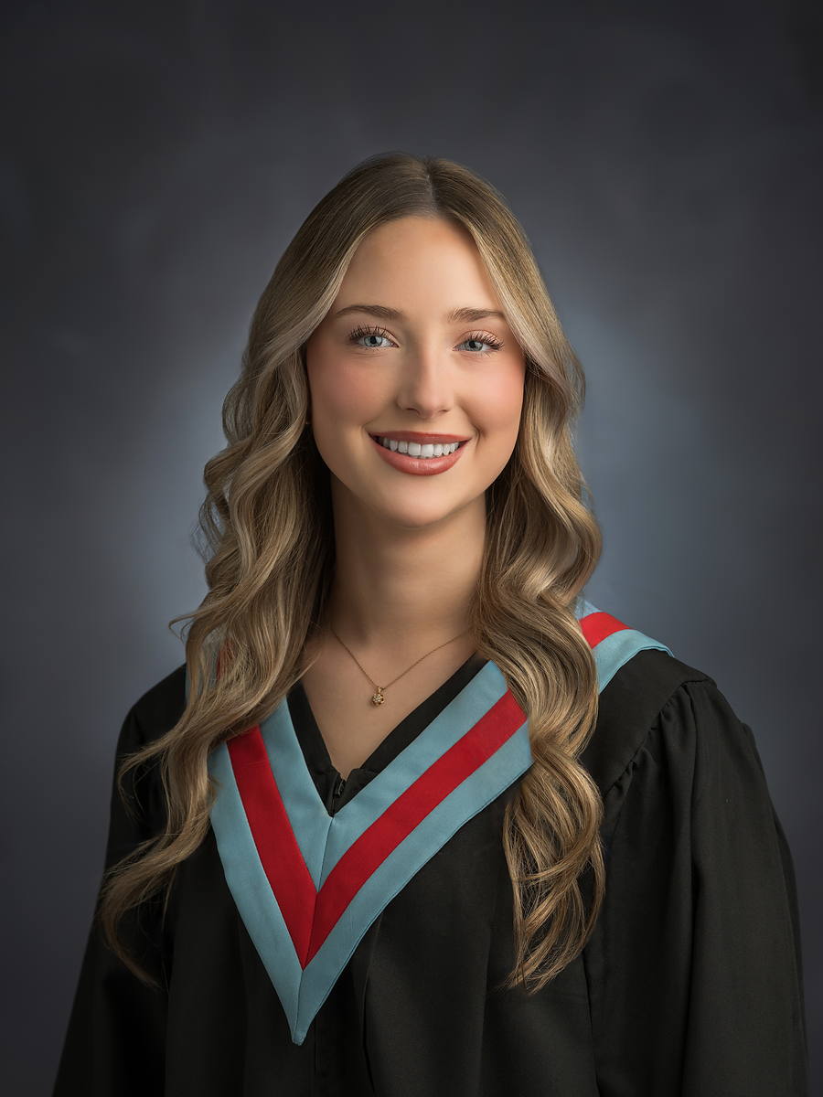 Bay View High grad with wavy hair in a black gown with light blue and red sash, Halifax